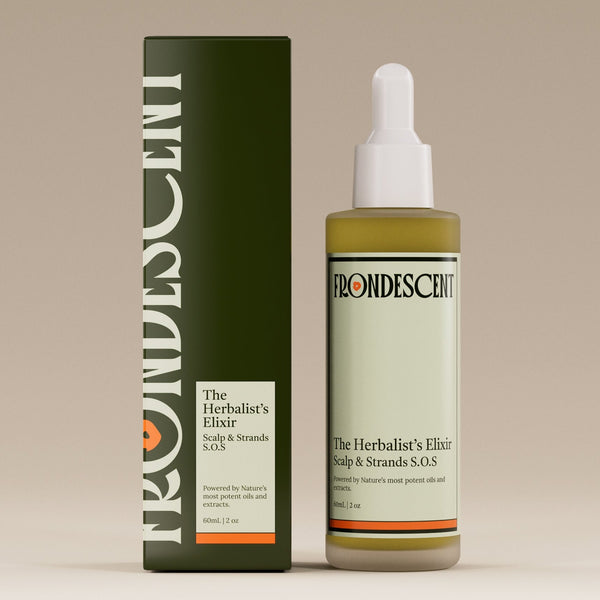 Bottle and box of Herbalist's Elixir Hair oil on a beige background