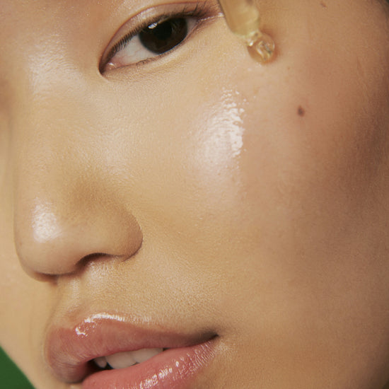 Close-up of a person applying dropper of liquid to their eye