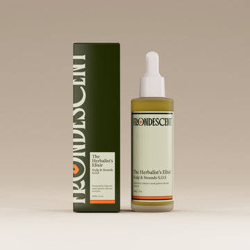 Bottle and box of Herbalist's Elixir Hair oil on a beige background