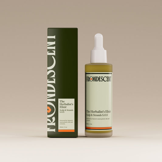 Bottle and box of Herbalist's Elixir Hair oil on a beige background