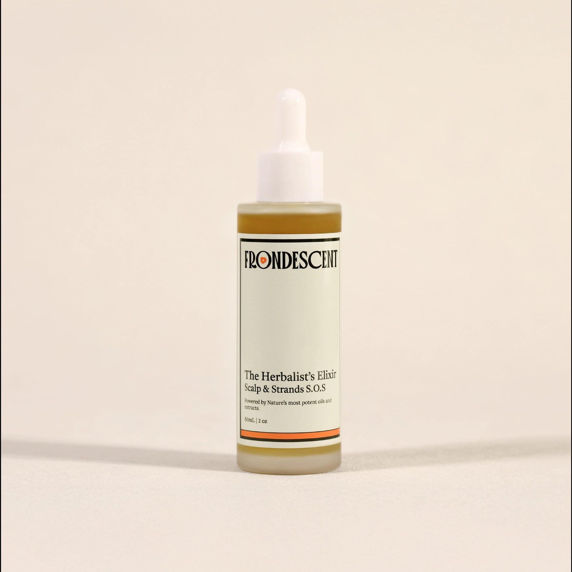 Bottle of 'The Herbalist's Elixir' by Frondescent on a beige background. Designed to give your hair the nutrients it needs. All natural ingredients.