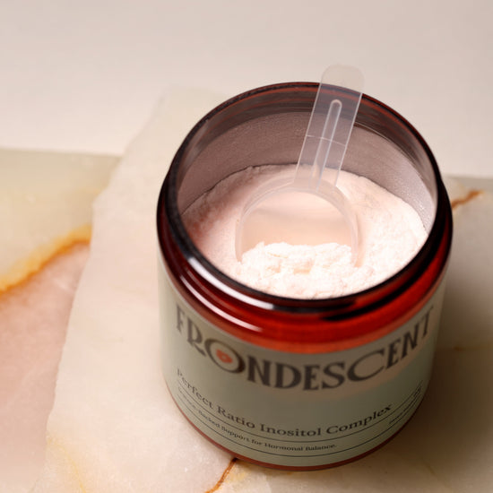 Jar of Frondescent product on a marble surface with a neutral background. Frondescent Perfect Ratio Inositol Complex powder supplement. Helps with hormones balance, and energy boost